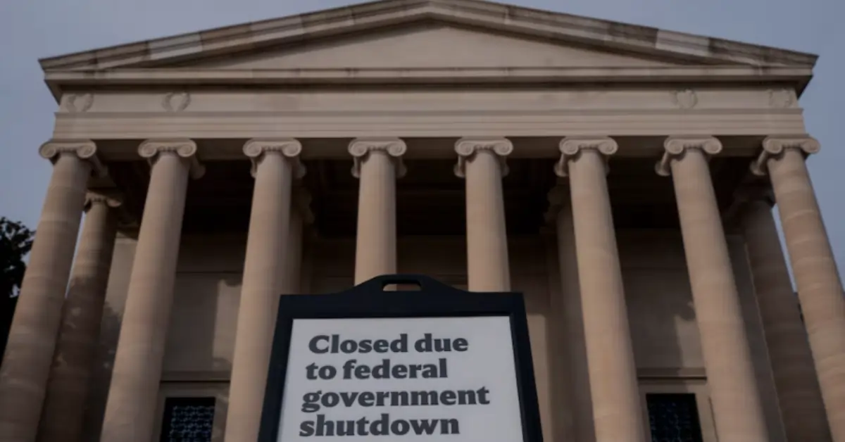 Sign reading "Closed due to federal government shutdown" displayed in front of a U.S. government building with columns.